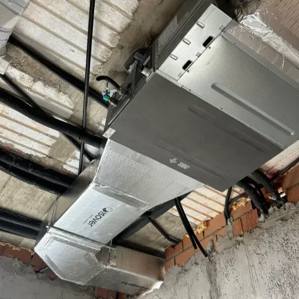 Conductos y unidad del sistema HVAC montados en un techo en un entorno de construcción.