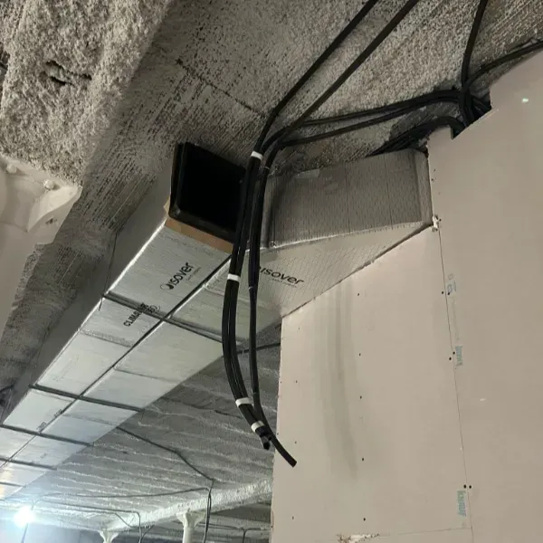 Conductos de HVAC y conductos eléctricos instalados en el techo. Los conductos son plateados y están aislados.