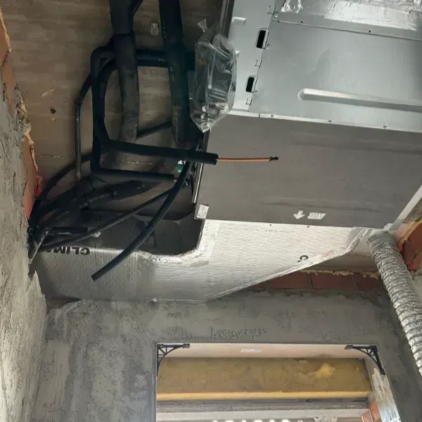 Conductos y tuberías de HVAC instalados en una cavidad del techo de un edificio en construcción.