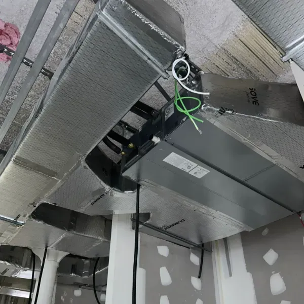 Instalación de conductos HVAC en un edificio, mostrando conductos metálicos, cableado y estructura del techo.