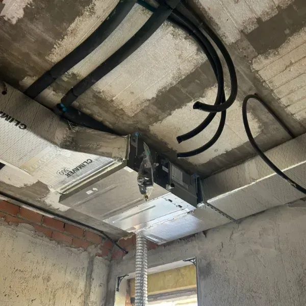 Conductos de HVAC y cableado eléctrico instalados en un techo de hormigón de un edificio en construcción.