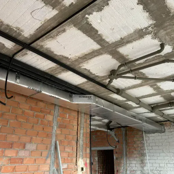 Obra: Muro de ladrillo visto, techo de hormigón con instalación de conductos y ductos.