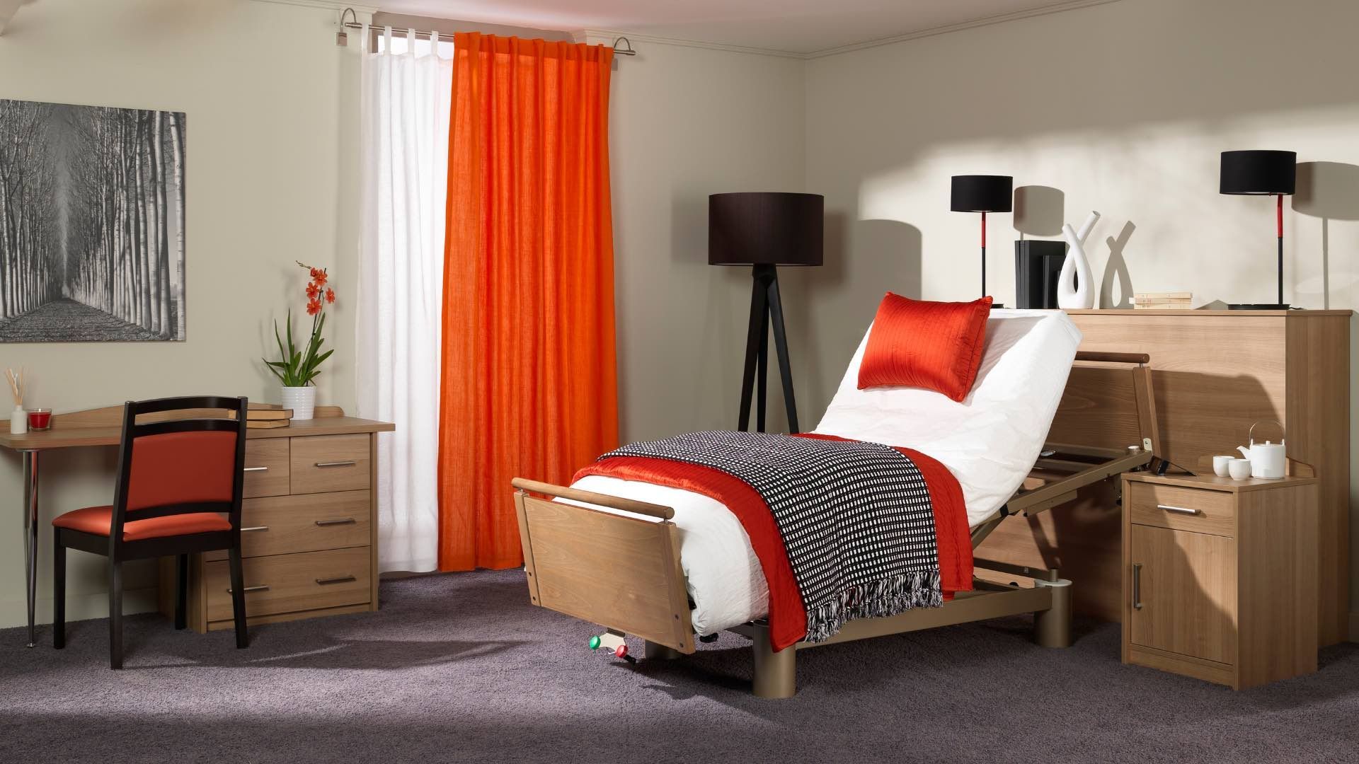 Chambre avec lit réglable, bureau, rideaux et lampes. Tons orange, blanc et bois, et couverture à imprimé zèbre noir.