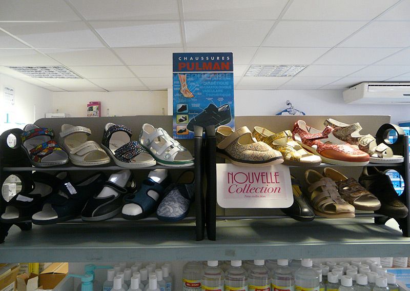 Des étagères présentent différents modèles de chaussures pour enfants dans un magasin.