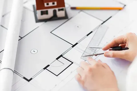 Una persona está usando una regla para medir el plano de una casa.