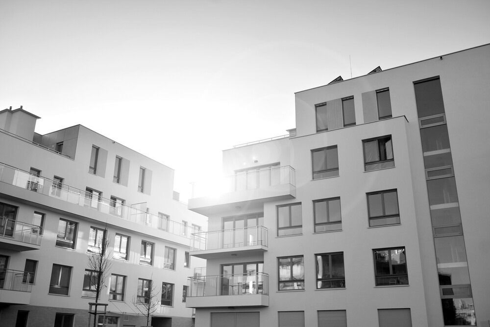Una fotografía en blanco y negro de un techo con paneles solares y una chimenea.