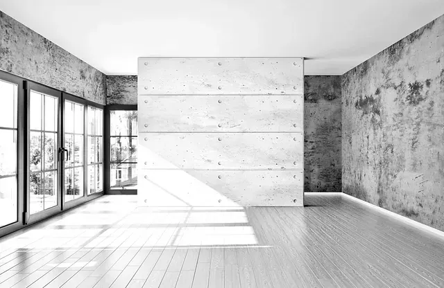 Es una fotografía en blanco y negro de una habitación vacía con una pared de hormigón.