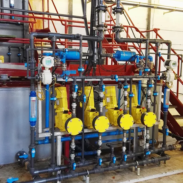 Una fila de bombas amarillas están alineadas en una fábrica