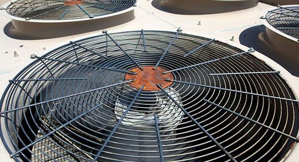 Un primer plano de un ventilador en la parte superior de un edificio.
