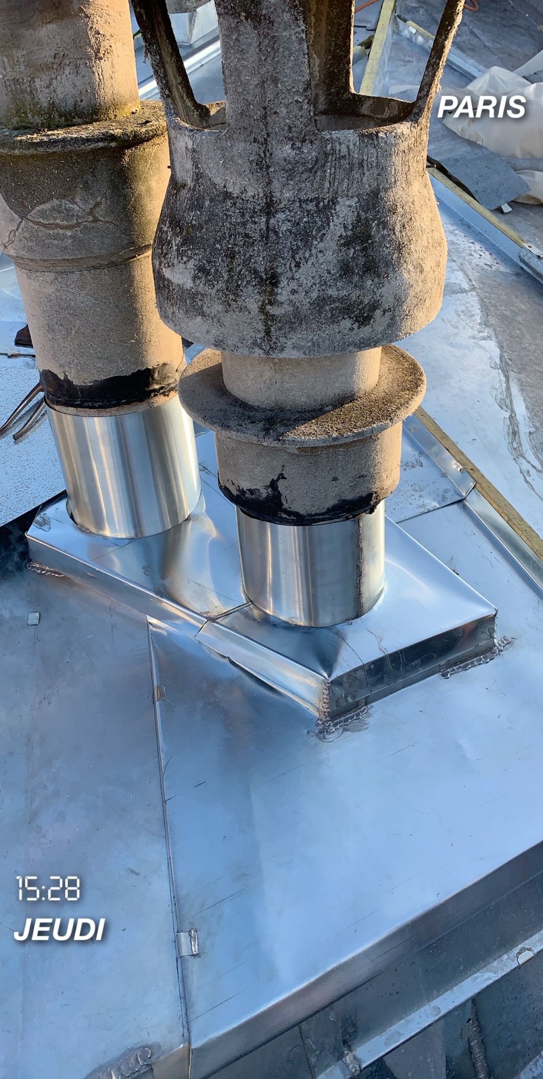 Cheminées sur un toit métallique à Paris, avec un horodatage.