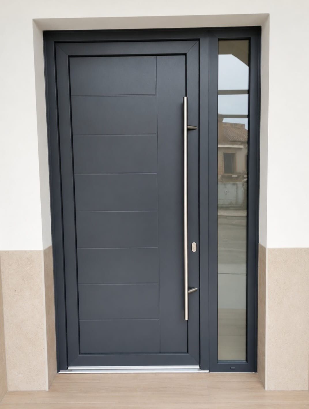 Puerta principal marrón con manija plateada y una pequeña luz de porche encima, enmarcada por paredes de color beige.