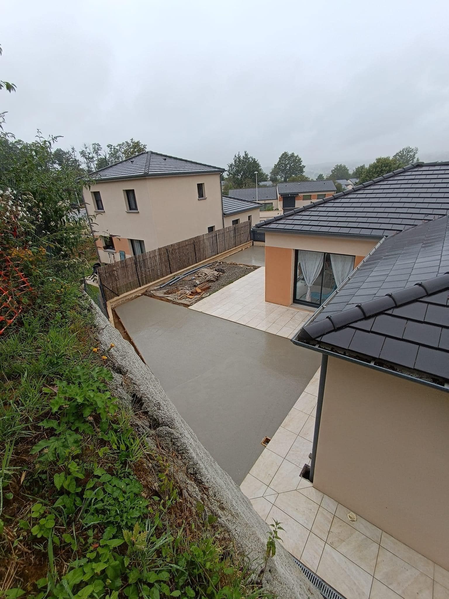 Chape de béton et terrasse en carrelage autour d'une maison