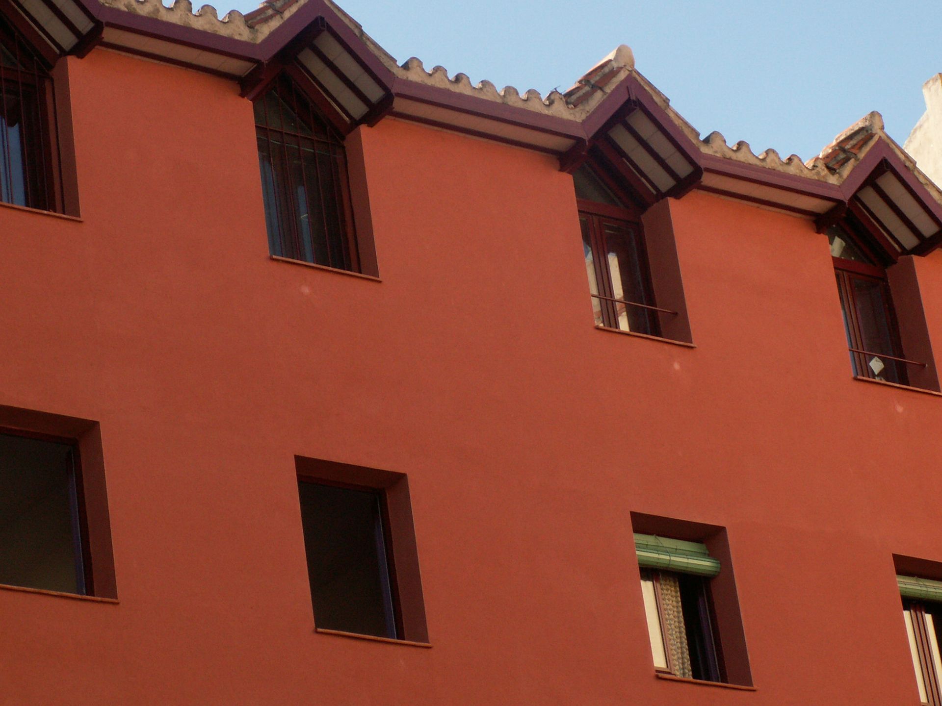 Un edificio rojo con muchas ventanas y un techo.