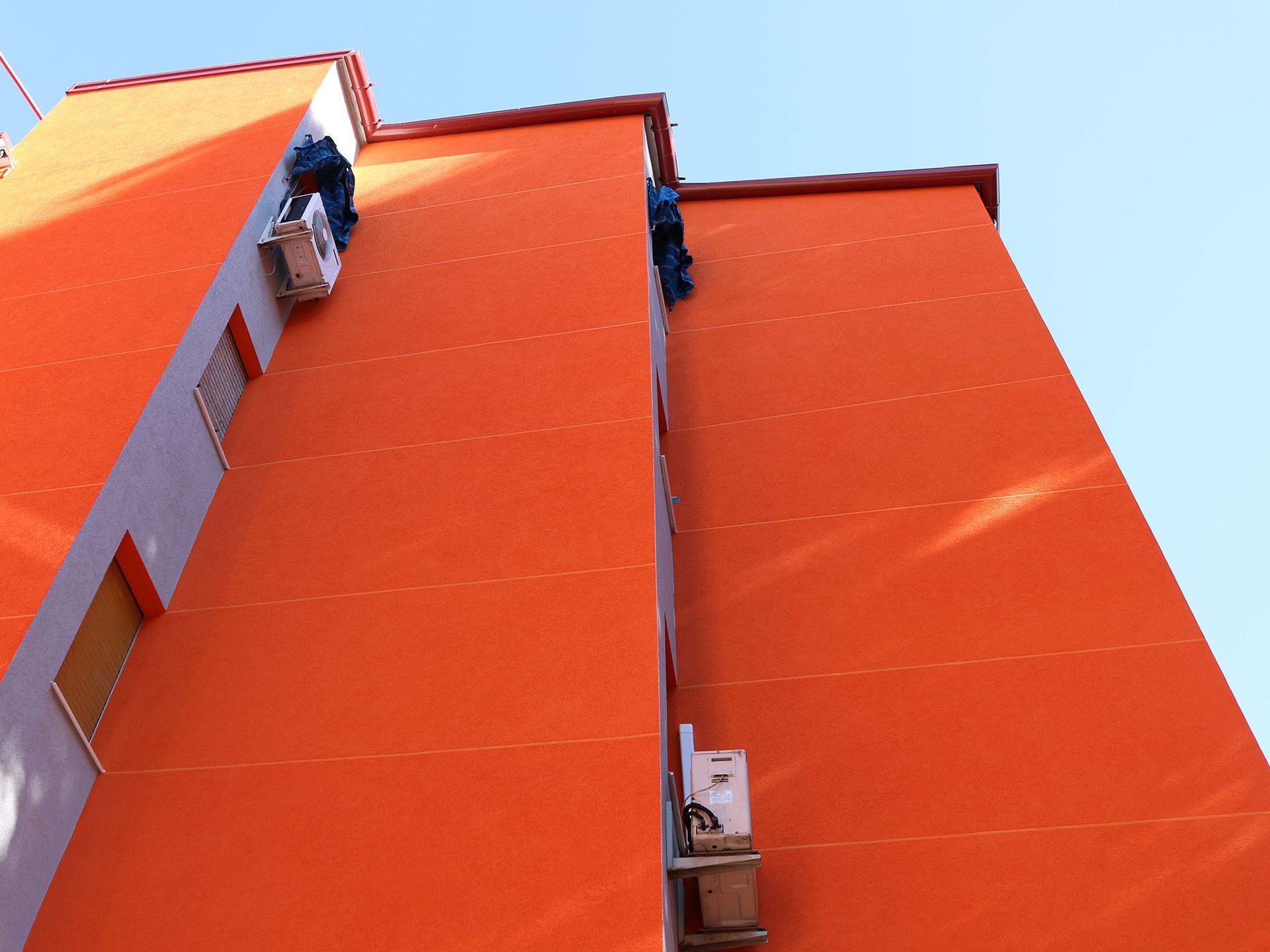 Un gran edificio naranja con un cielo azul al fondo.