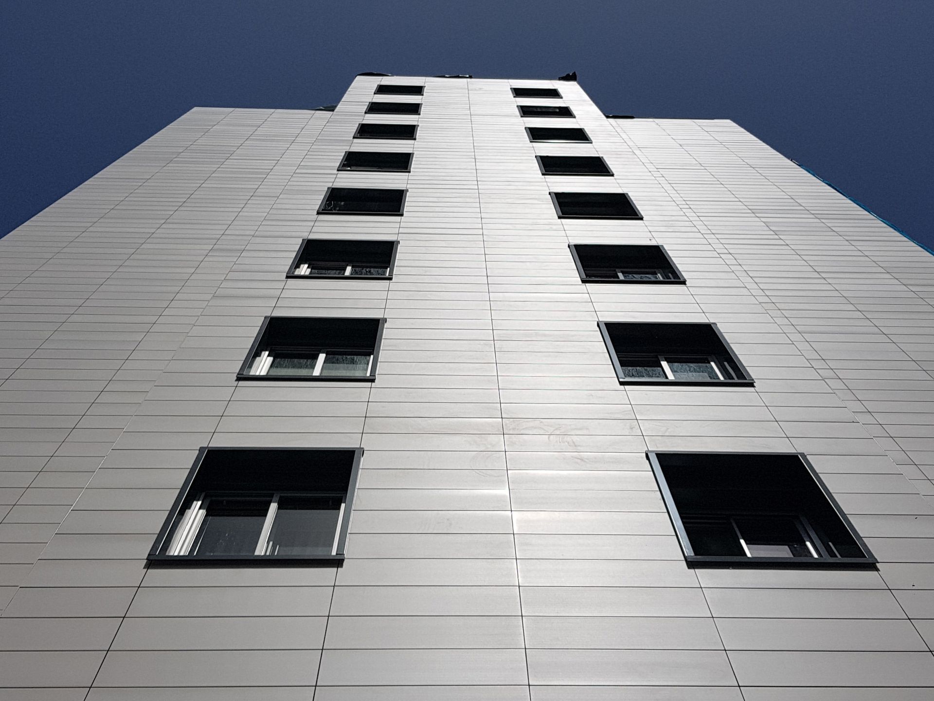 Mirando hacia arriba a un edificio alto con muchas ventanas