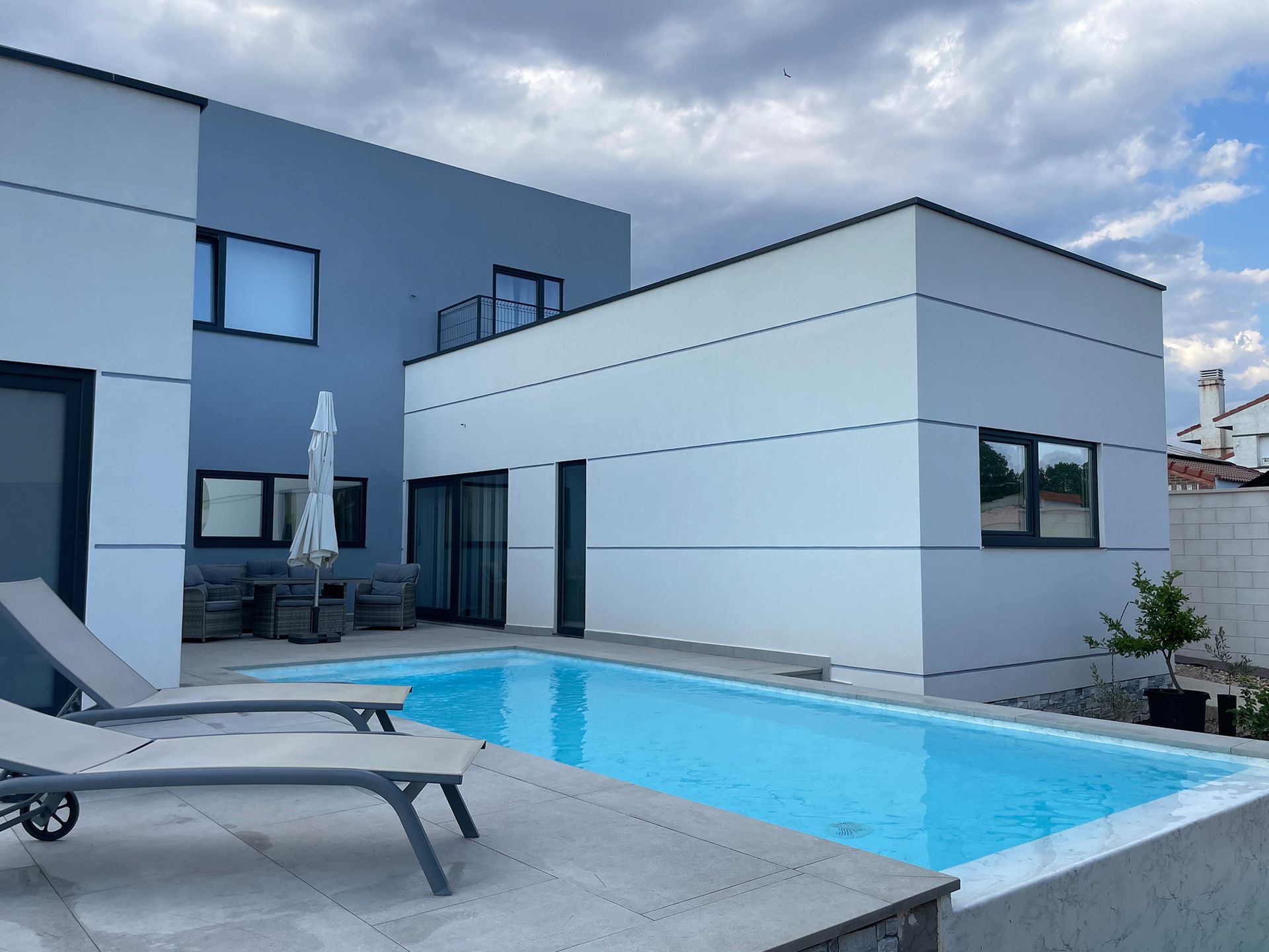 Una casa grande con piscina delante de ella.