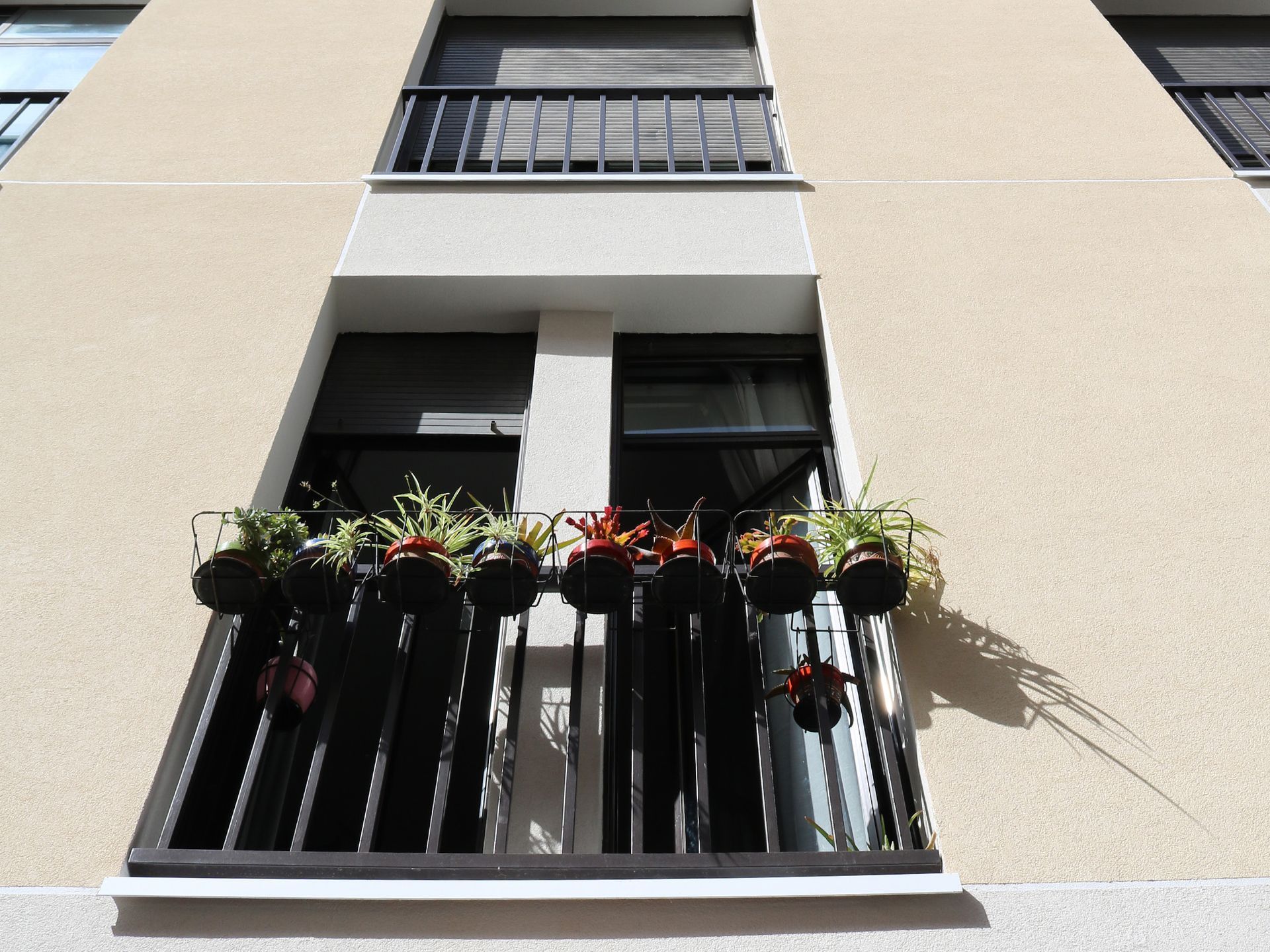 Un edificio con un balcón con plantas en macetas.