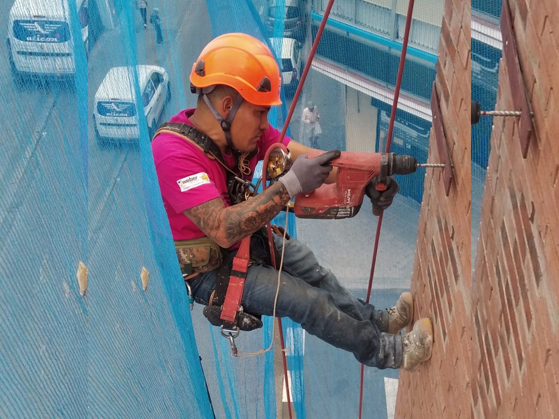 Un hombre está usando un taladro en una pared de ladrillos.
