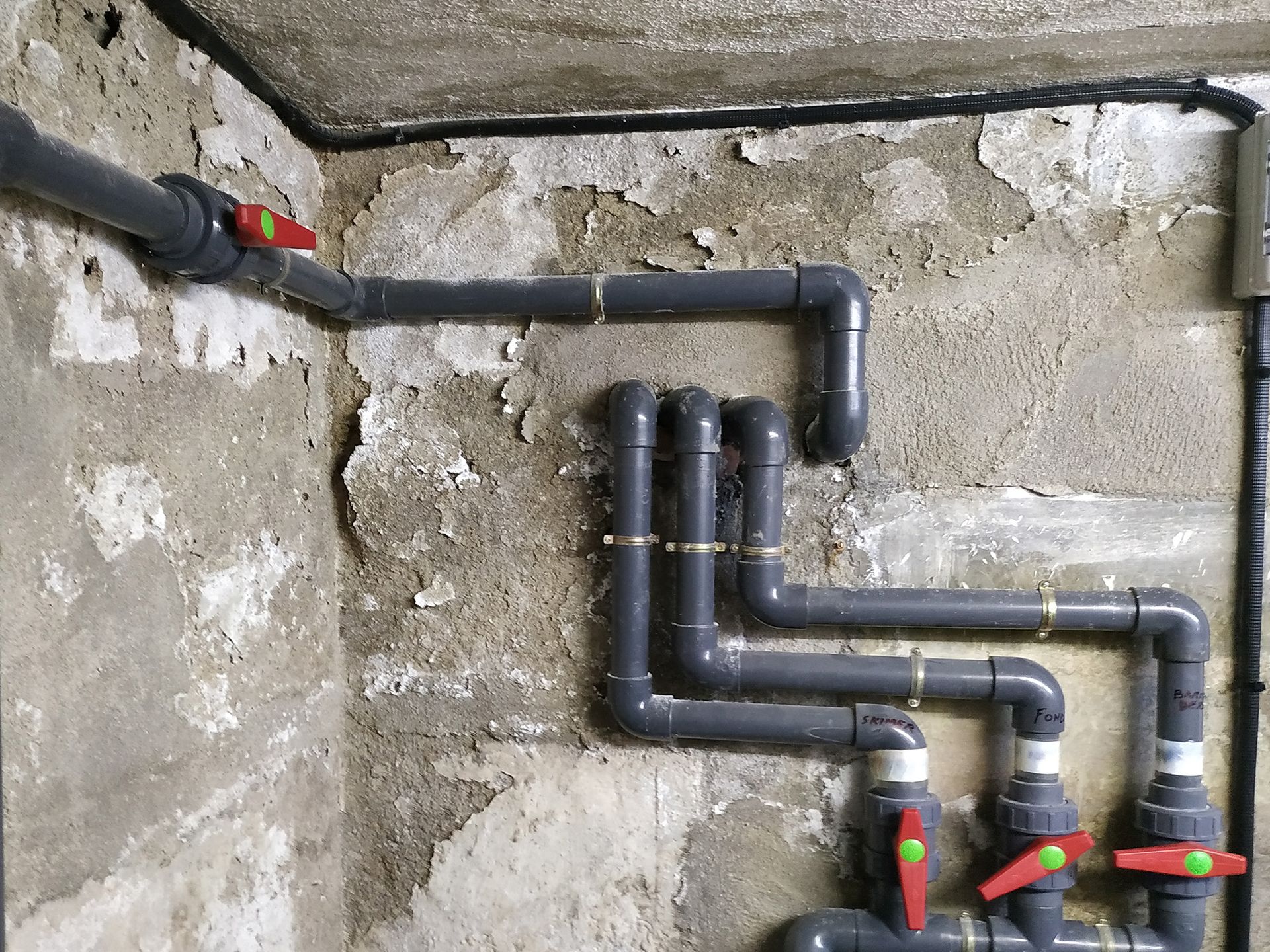 Un montón de tuberías están conectadas a una pared de una habitación.