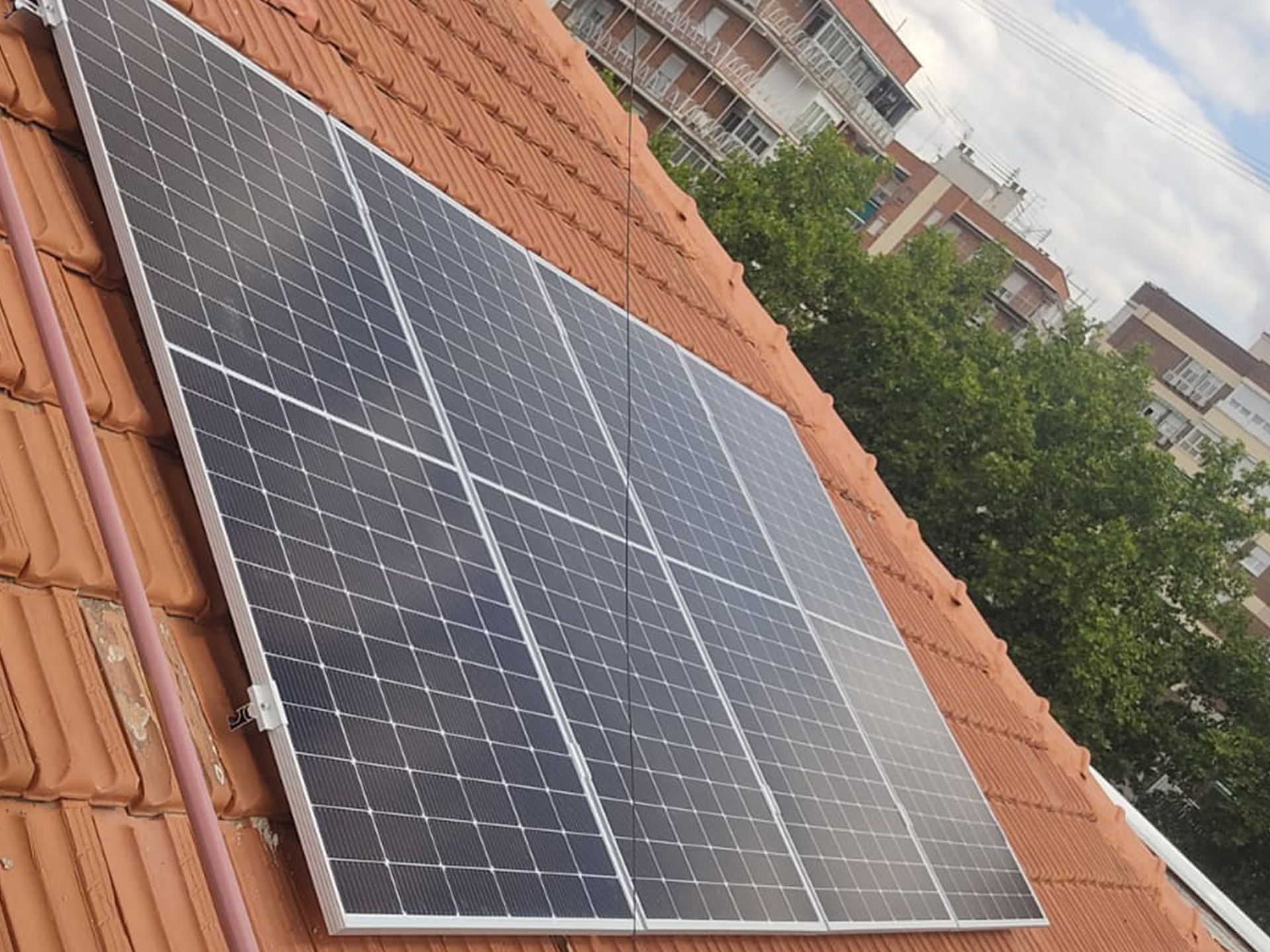 Una fila de paneles solares sobre un tejado de tejas