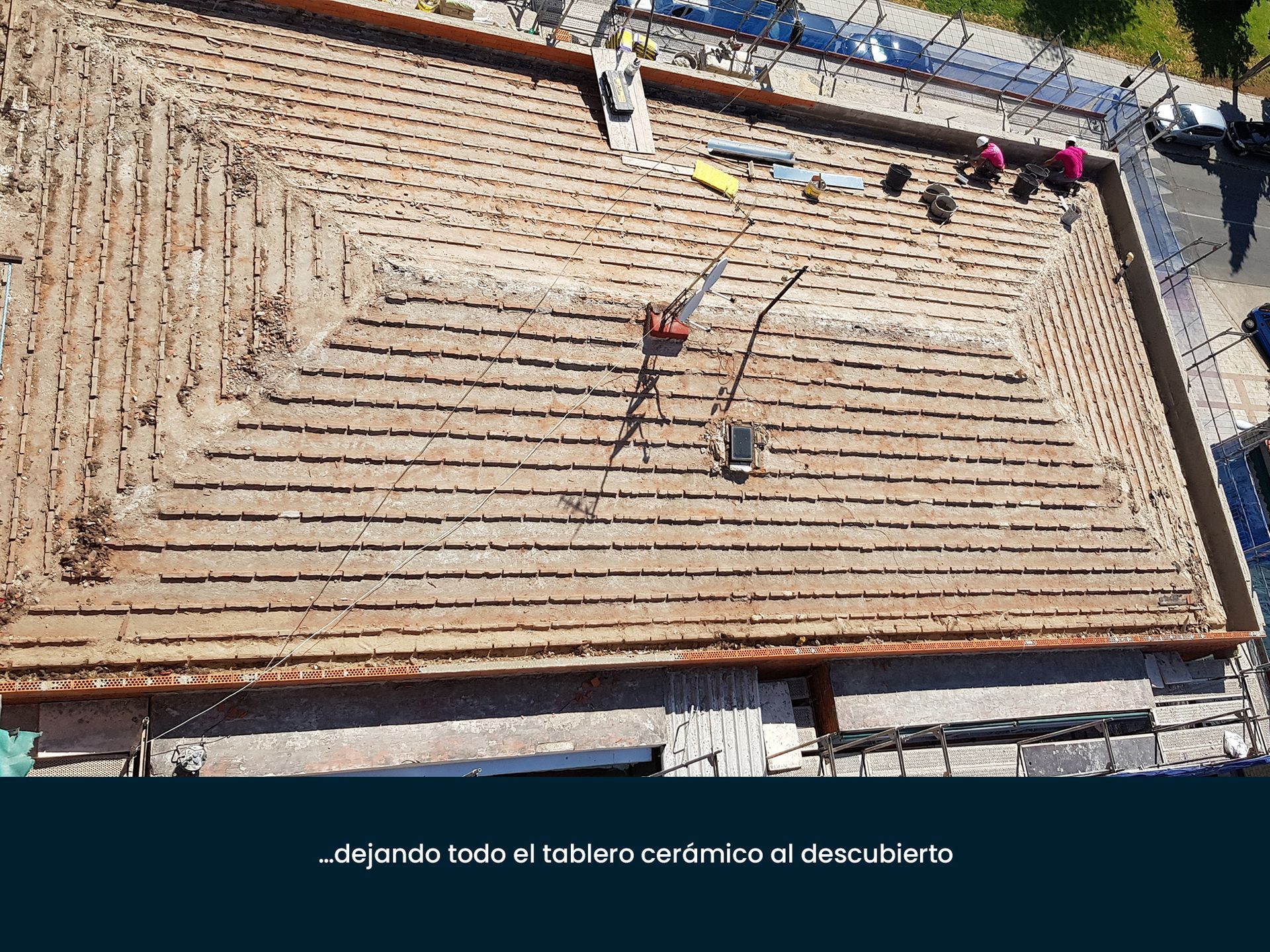 Una vista aérea de un edificio en construcción con trabajadores en el techo.