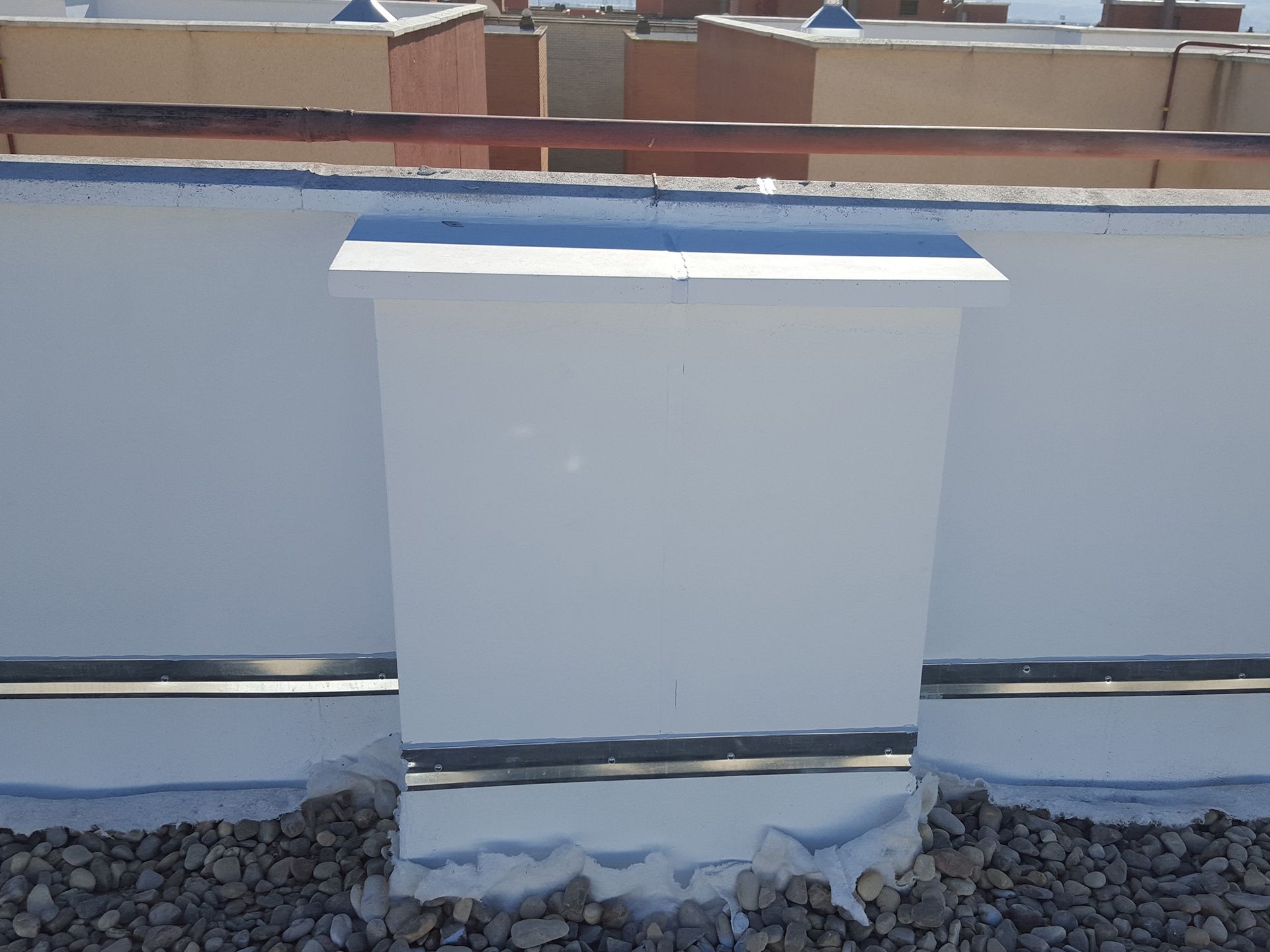 Una caja blanca está sentada encima de un techo rocoso.