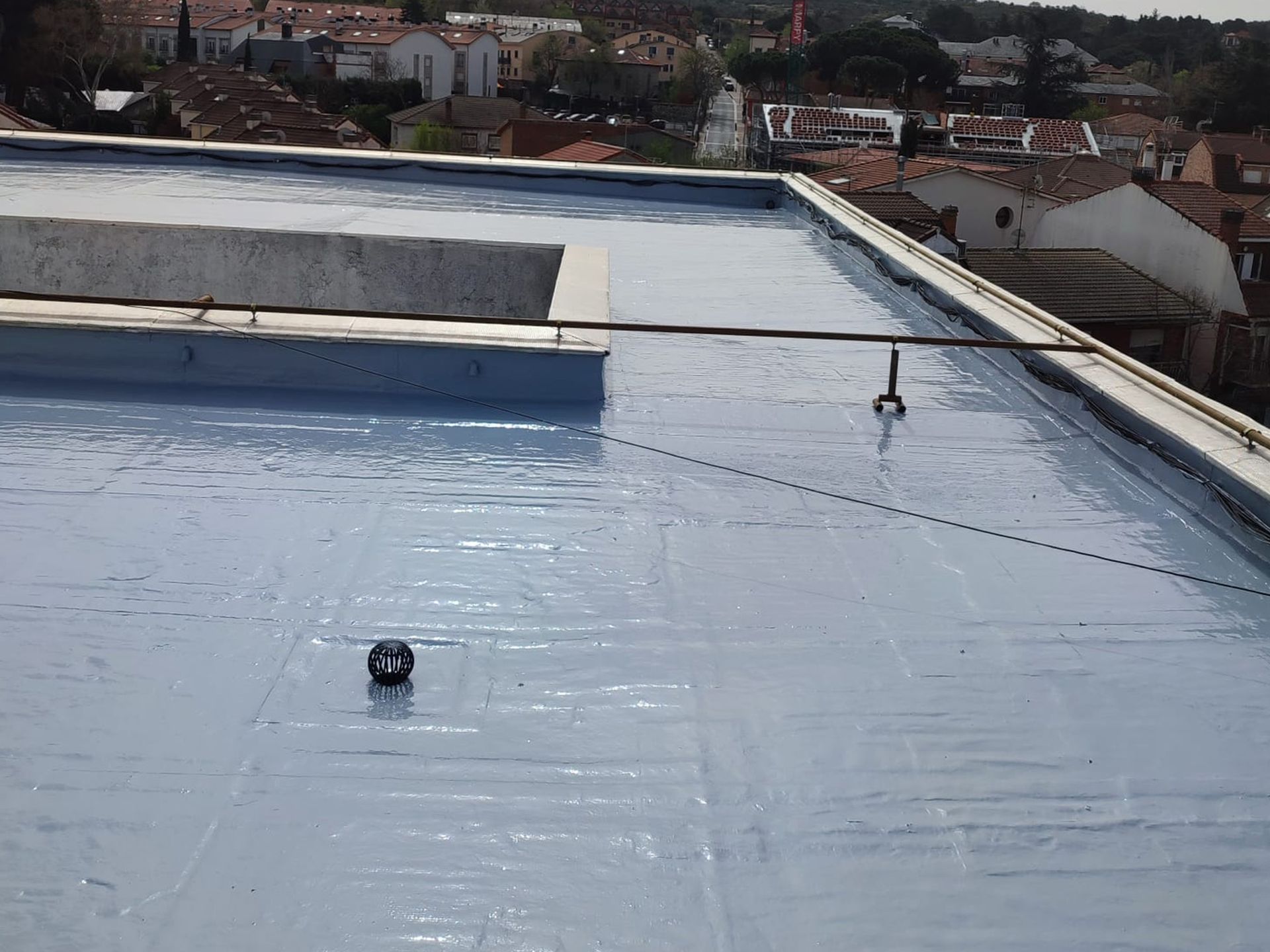 El techo de un edificio está cubierto con una capa de pintura azul.