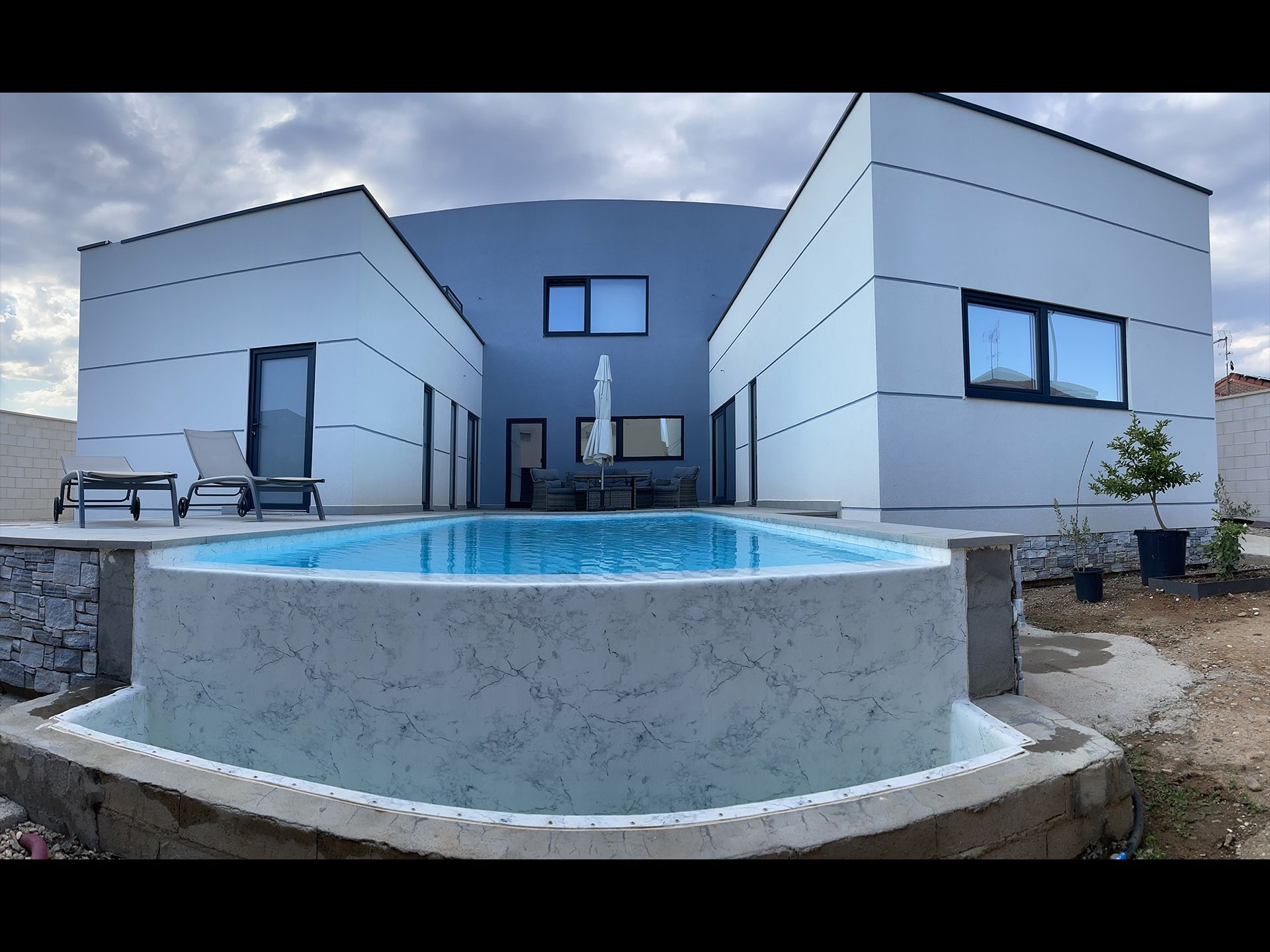 Una casa grande con piscina delante de ella.