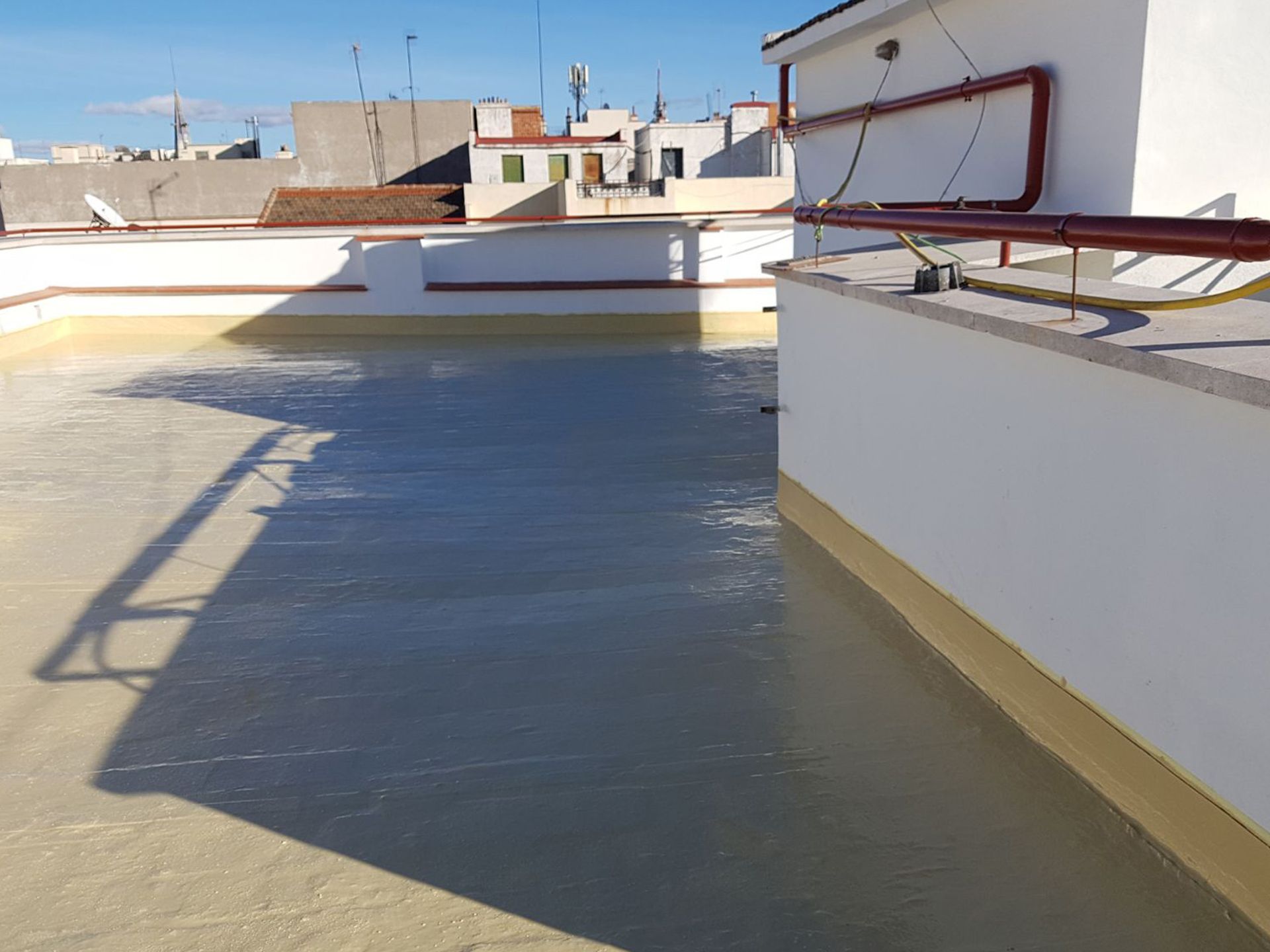 La sombra de un edificio se proyecta sobre un suelo de hormigón.