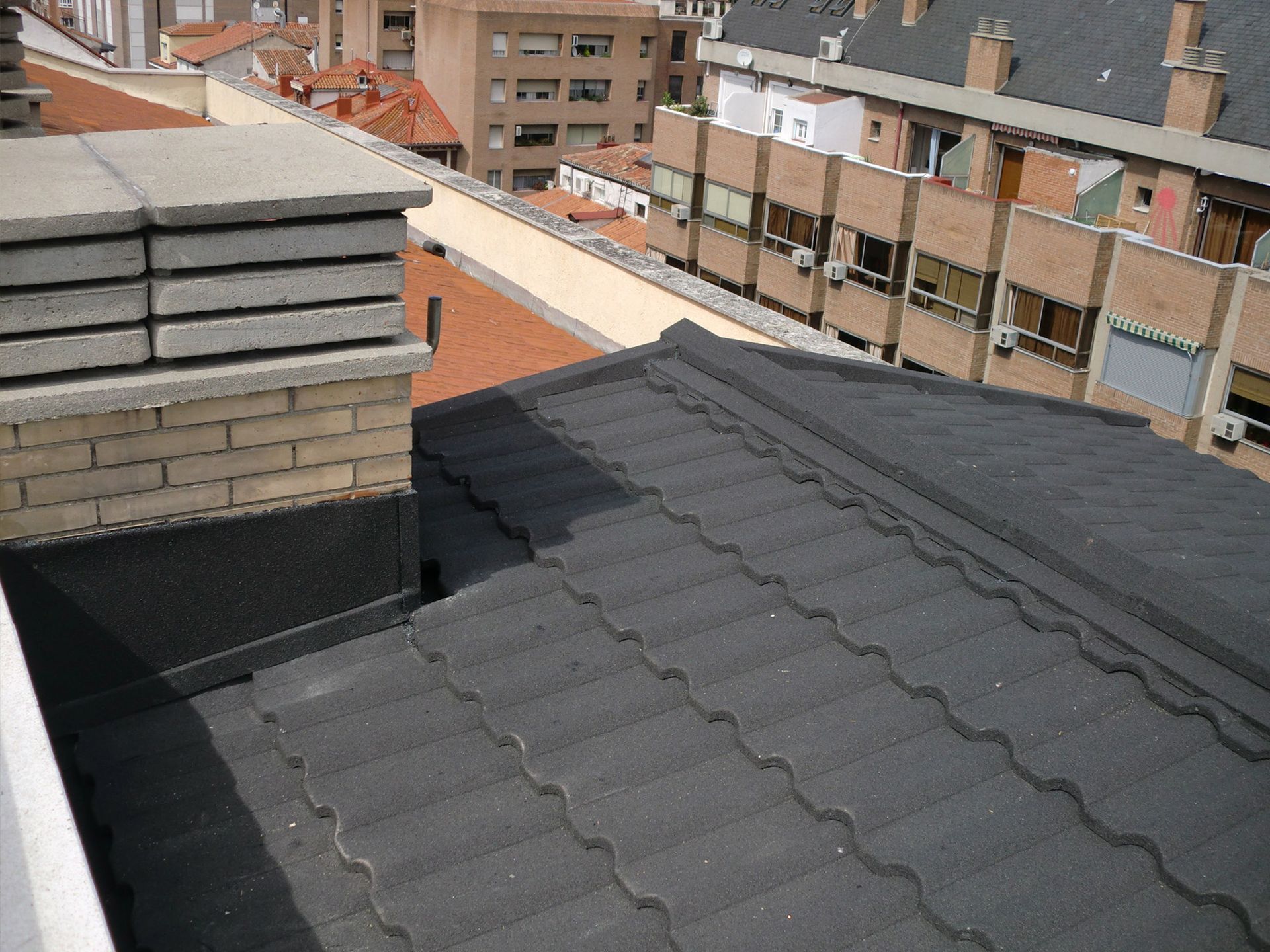 Un techo negro con una chimenea encima.