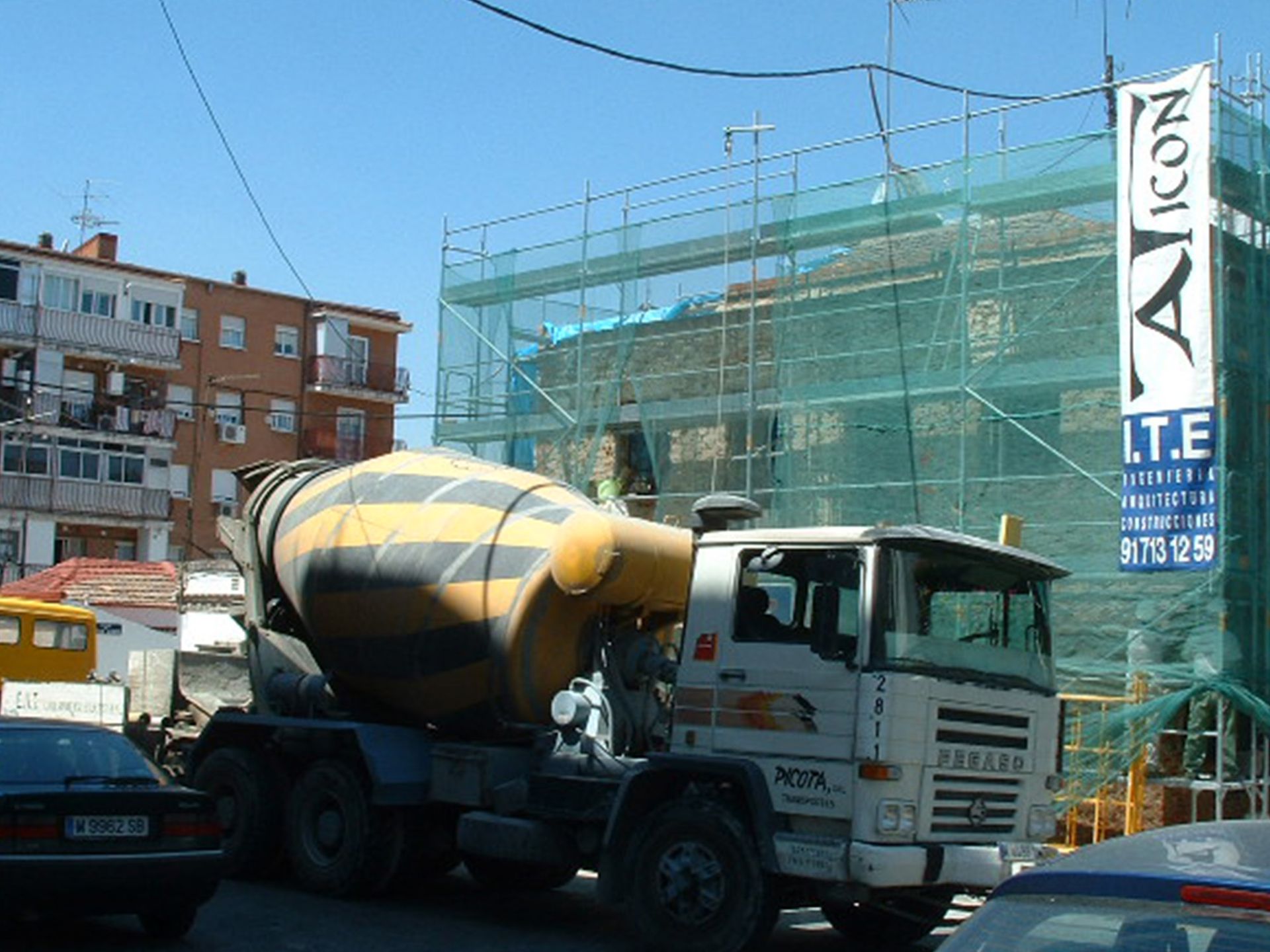 Un camión hormigonera está estacionado frente a un cartel que dice Nova