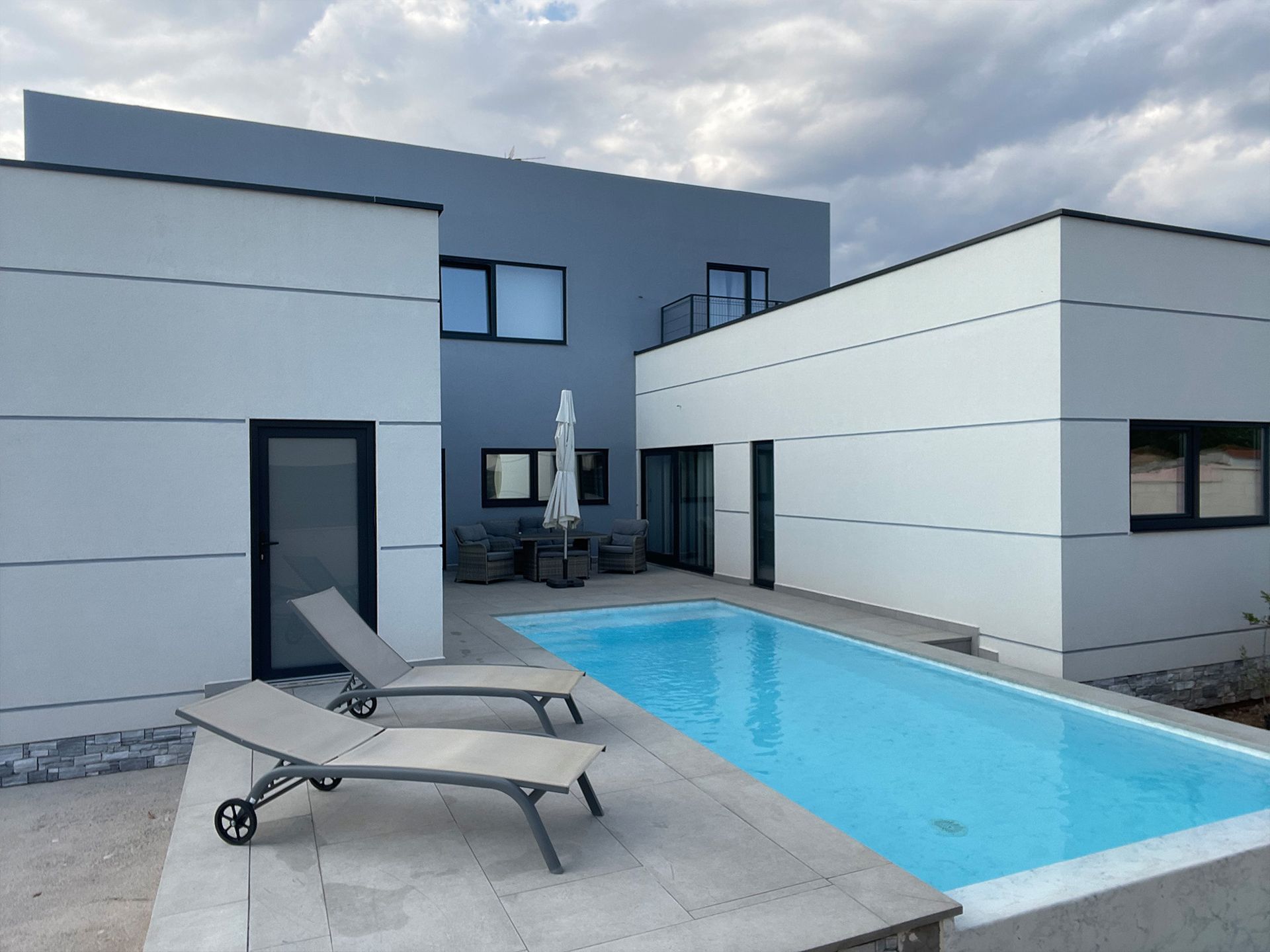 Una casa grande con piscina delante de ella.