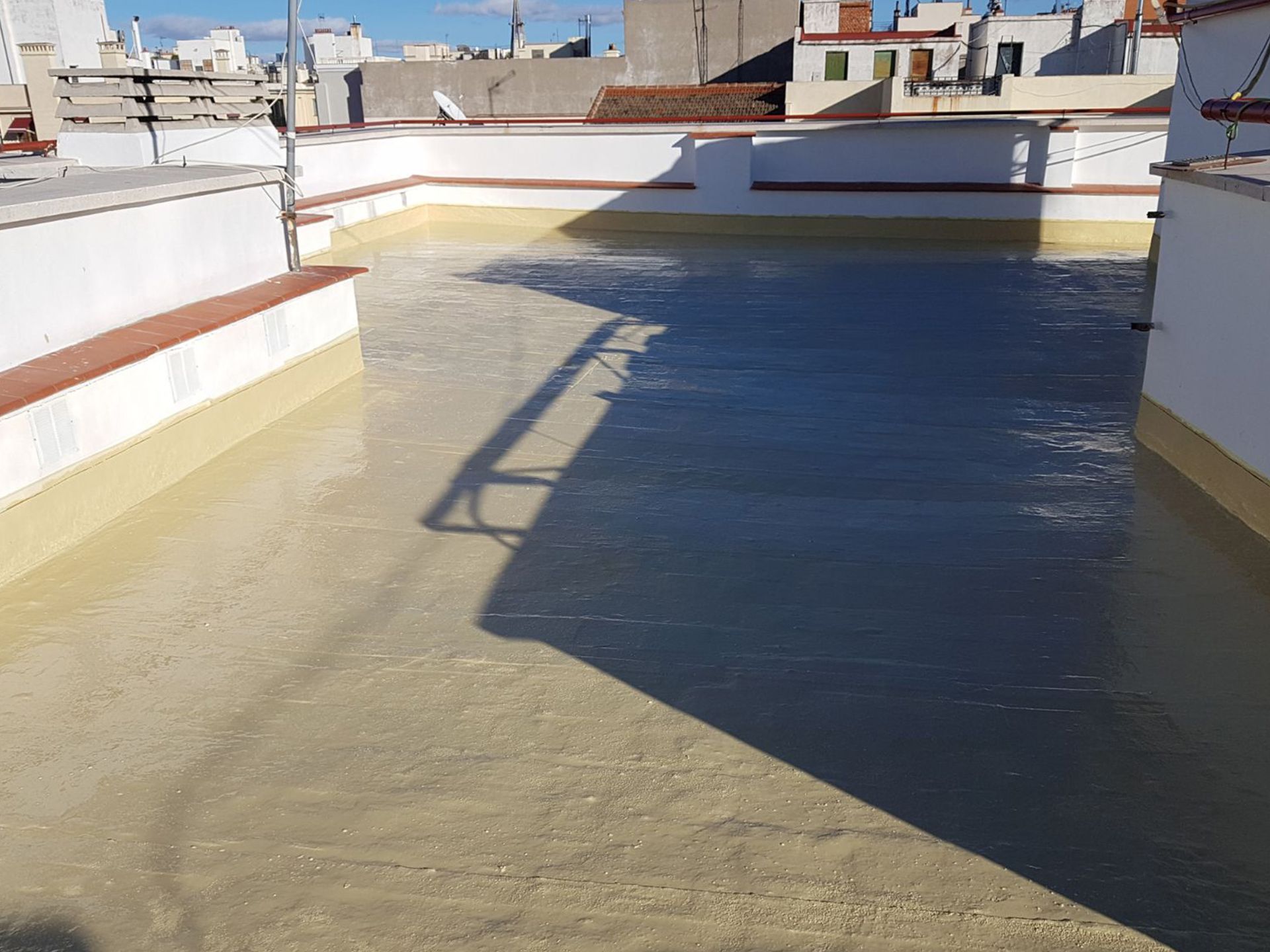 Un tejado con la sombra de un edificio sobre él