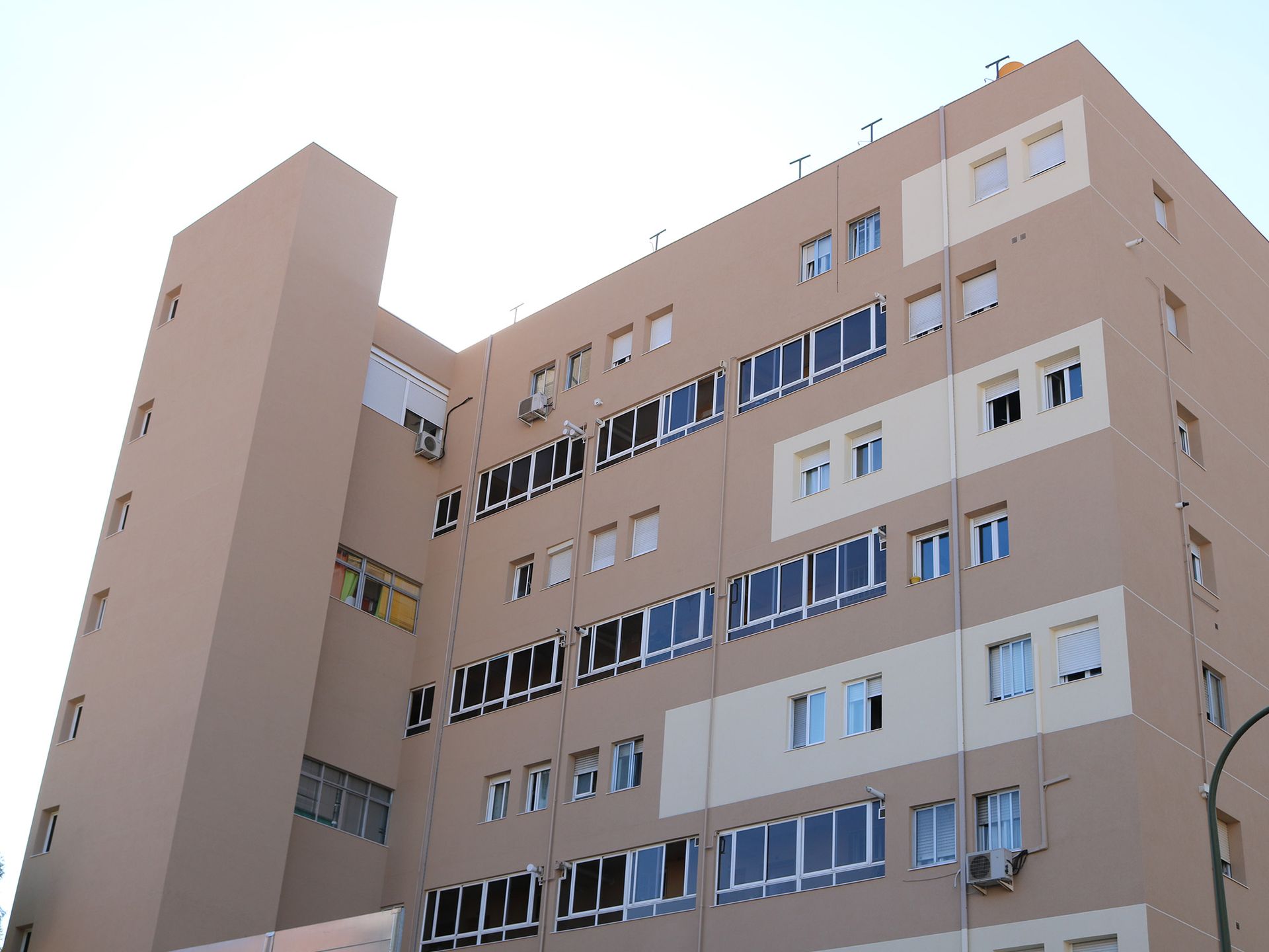 Un gran edificio con muchas ventanas y un cielo azul al fondo.