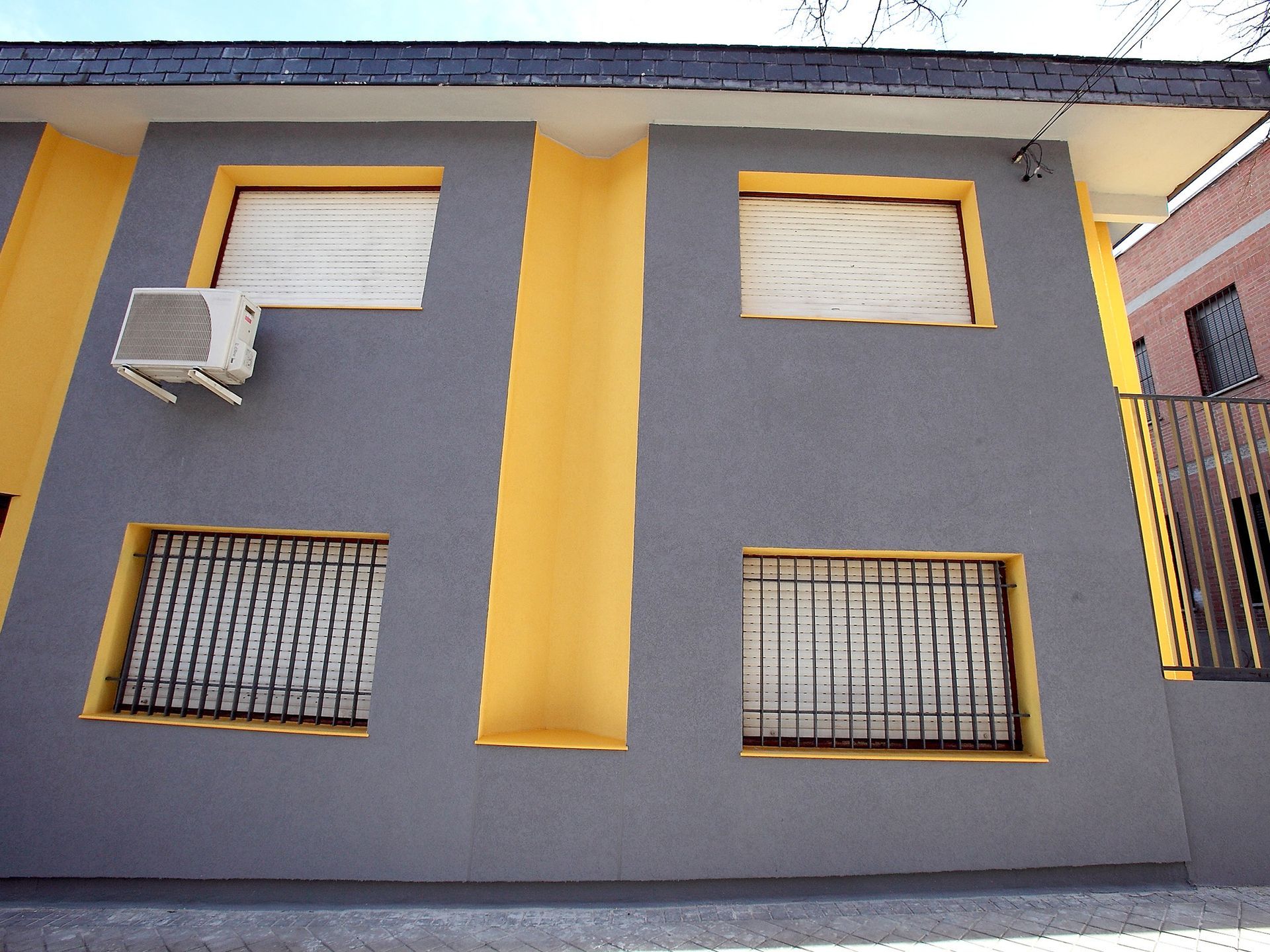 Un edificio gris y amarillo con algunas ventanas.