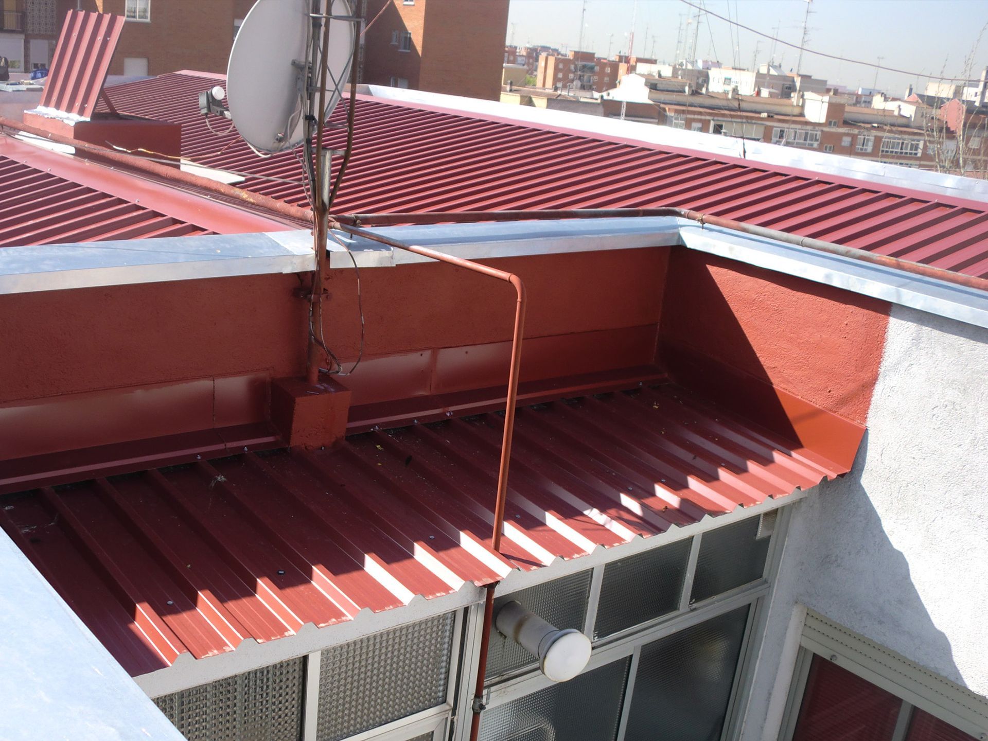 Un techo rojo con una antena parabólica encima