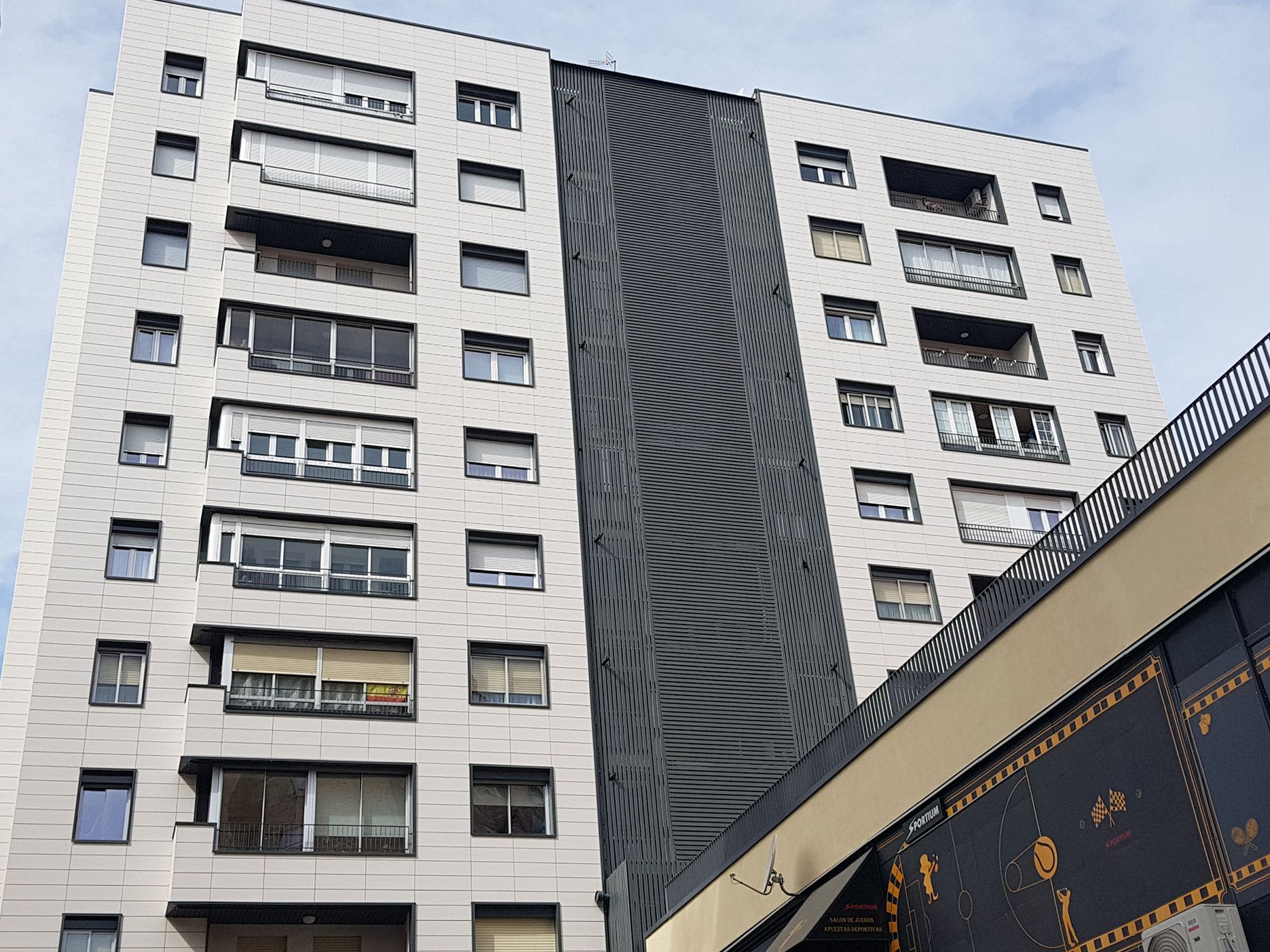 Un edificio alto con muchas ventanas y balcones.