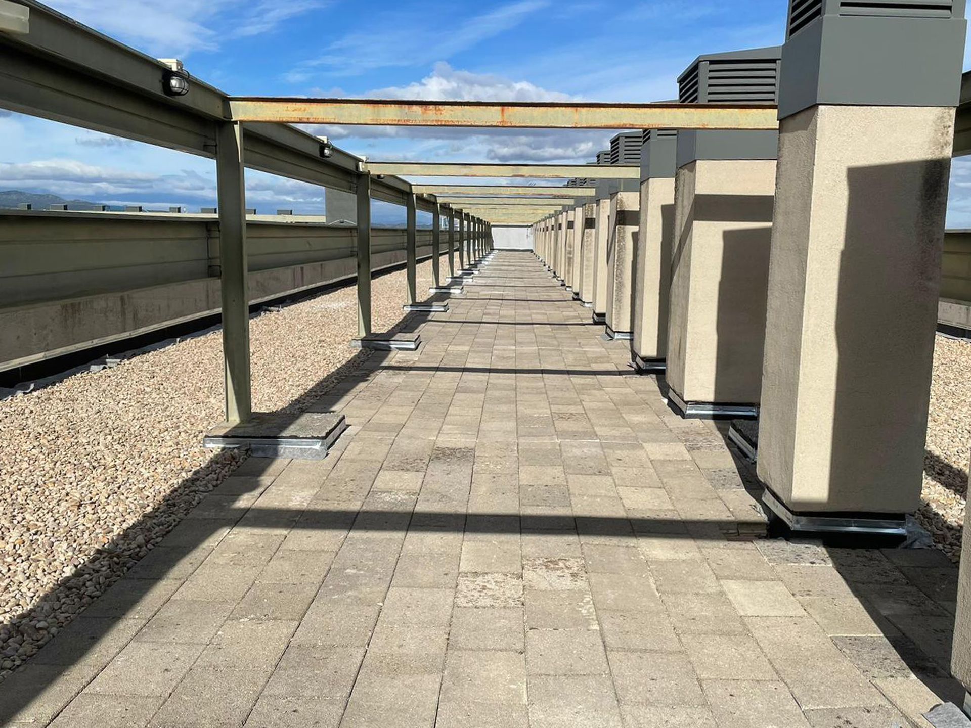 Una fila de columnas a lo largo de una pasarela en la parte superior de un edificio