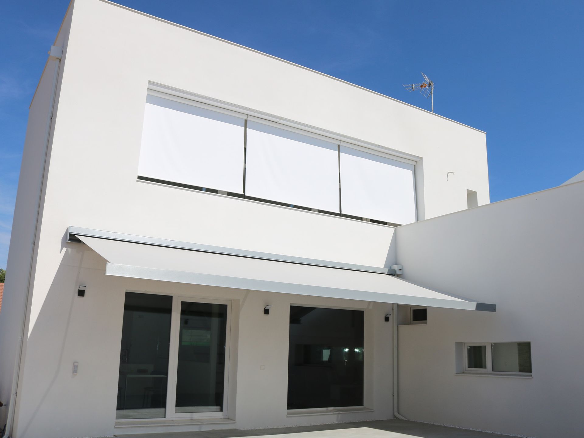 Un edificio blanco con un toldo blanco al costado.