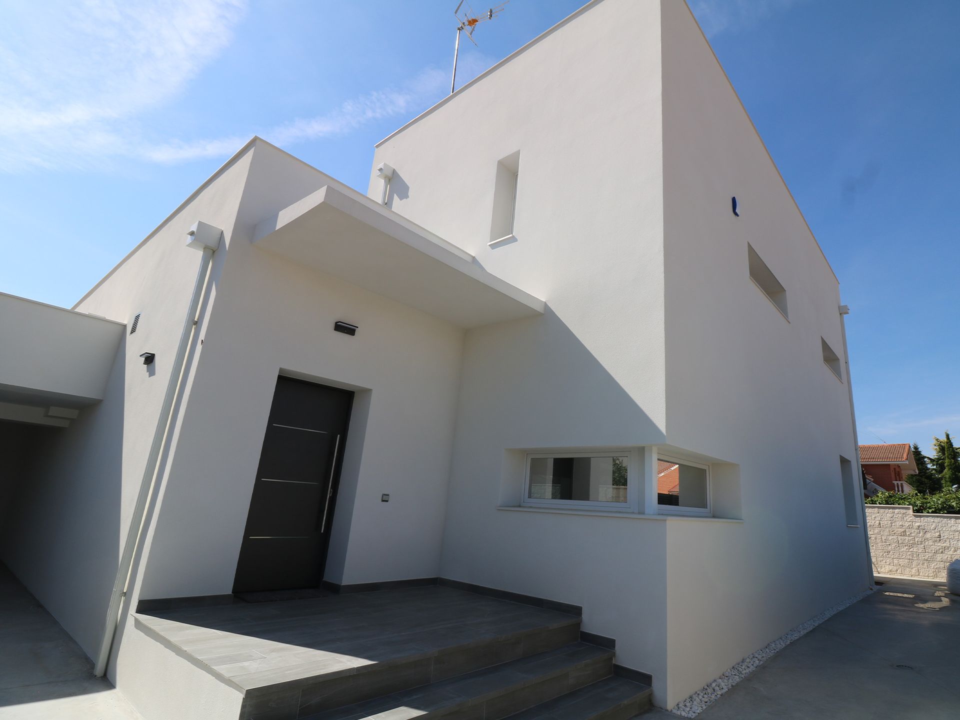 Una casa blanca con una puerta y escaleras negras