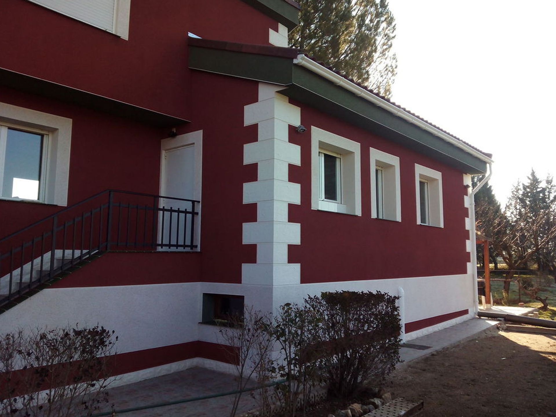 Una casa roja y blanca con escaleras que conducen a ella.