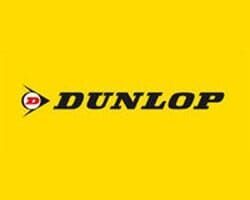 Logotipo da Dunlop: marca denominativa preta com um emblema vermelho e branco sobre um fundo amarelo.