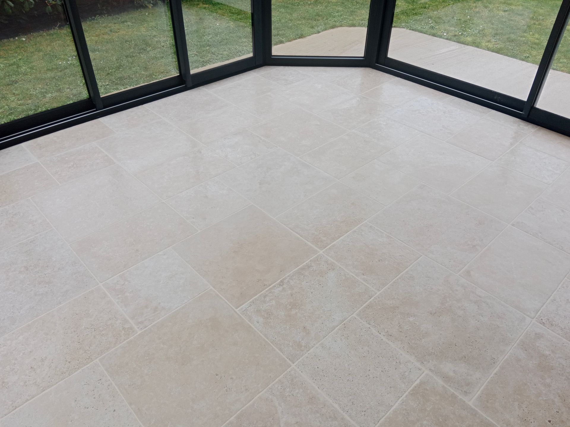 Un carrelage imitation bois avec des joints clairs mène à un meuble d'angle à étagères ouvertes.