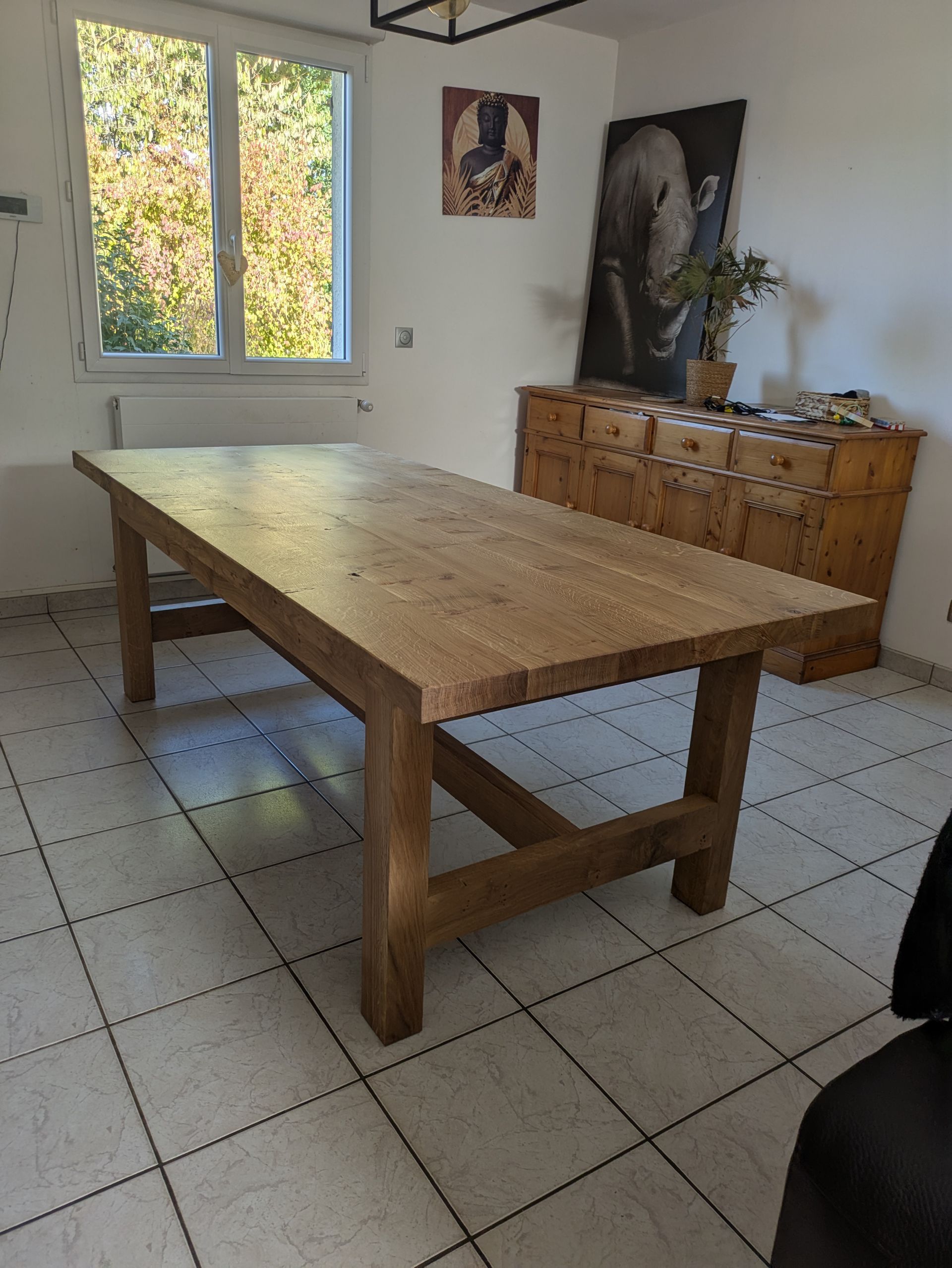 Sol carrelé gris dans une pièce avec de grandes portes vitrées aux cadres sombres.