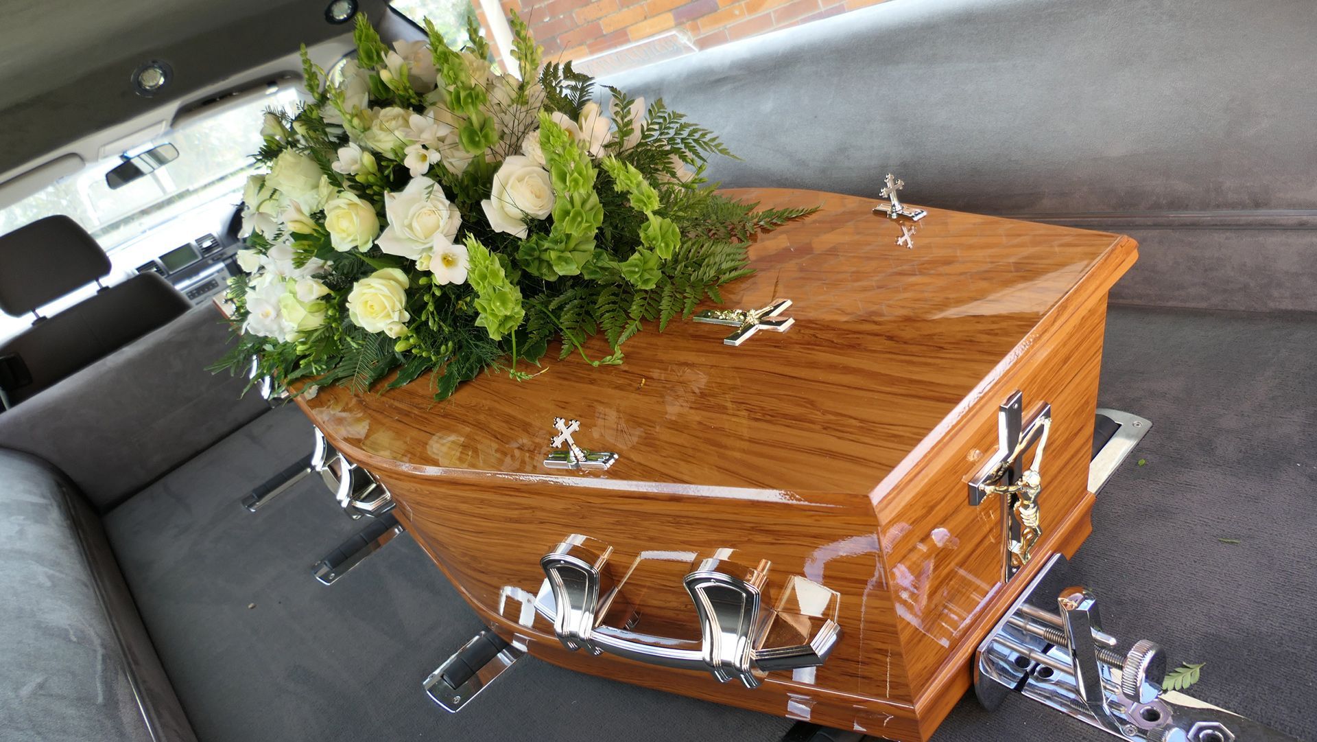 Pessoas apreciando o pôr do sol do alto de uma montanha, com os braços erguidos.