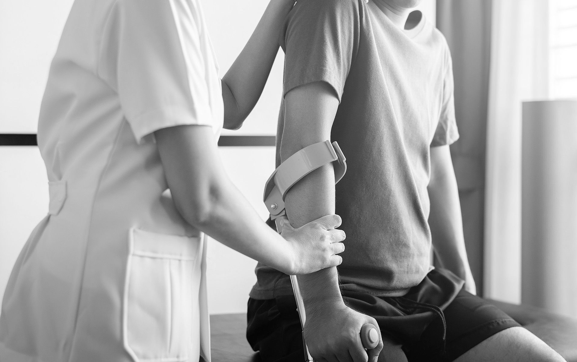 Un médecin aidant un patient à utiliser des béquilles lors d'une séance de rééducation.