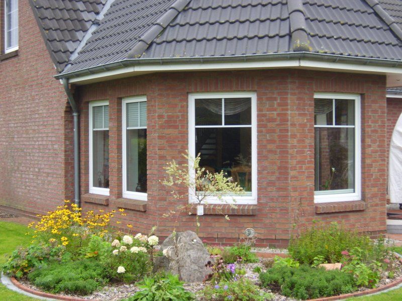 Ein Backsteinhaus mit einem Garten davor