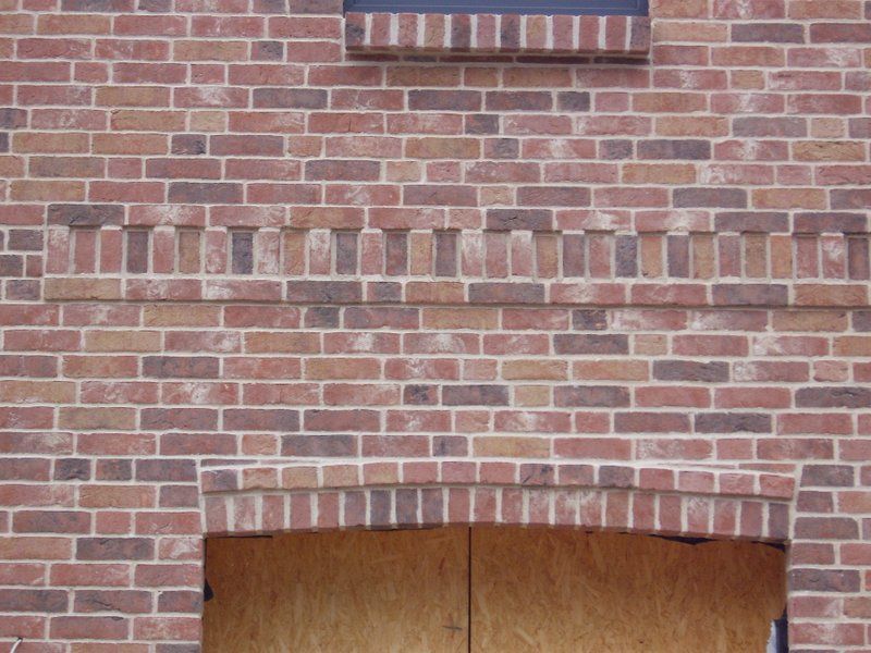 Eine Ziegelwand mit einer Holztür in der Mitte