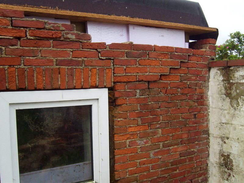 Eine Ziegelmauer mit einem Fenster und einem Dach