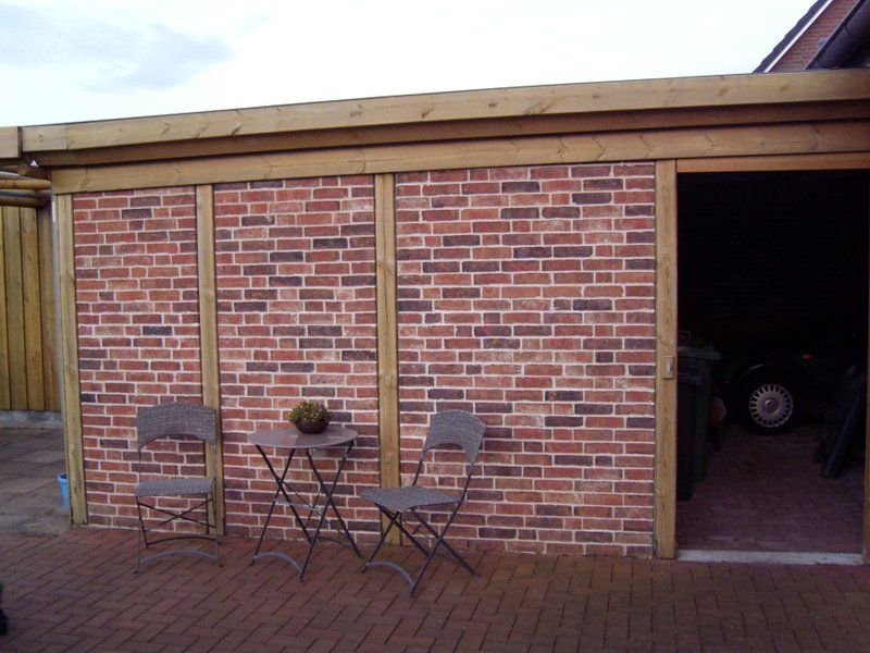 Eine Ziegelwand mit einem Tisch und Stühlen davor